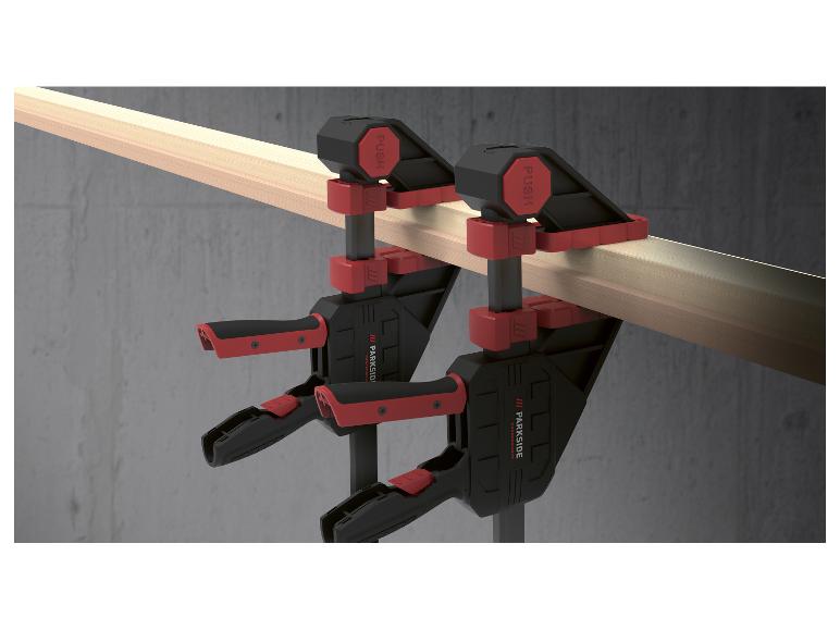 Zwei Parkside Performance Schraubzwingen spannen ein Holzstück zusammen.