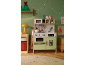 Kinder-Spielküche mit Weihnachtsdekoration und Kinderzeichnungen.