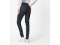 Frau in dunklen Jeans und weißem Hemd, von hinten gesehen.