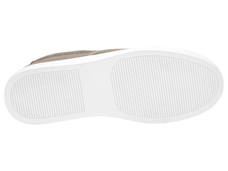 Sohle eines beigen Sneakers mit weißer Gummisohle und vertikalen Streifen.