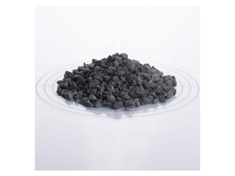 Ein Haufen dunkelgrauer Ziersteine auf einer transparenten Platte mit Maßen.