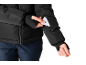 Frau in schwarzer Jacke und dunkelblauer Hose, steckt Karte in Ärmeltasche.