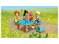 Drei LEGO Friends Figuren picknicken draußen mit Tisch und Stühlen.