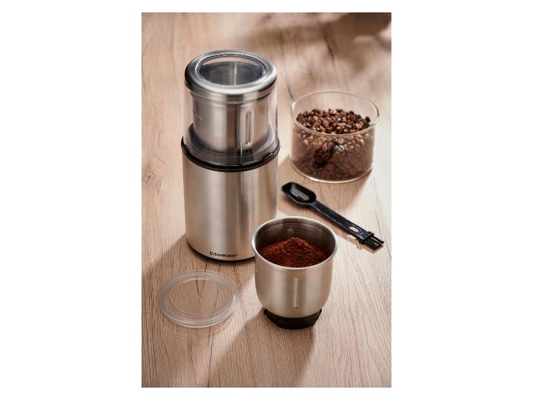 SilverCrest Kaffeemühle aus Edelstahl mit Kaffeebohnen und gemahlenem Kaffee.
