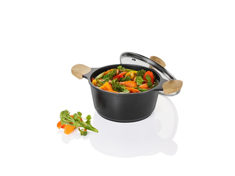 Schwarzer Topf mit Gemüse, Glasdeckel.