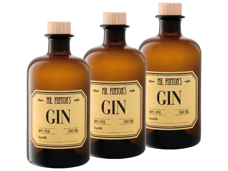 Drei bernsteinfarbene Gin-Flaschen mit Holzstopfen und Etiketten im Vintage-Stil.