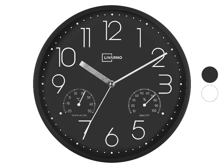 Schwarze Wanduhr mit integriertem Thermometer und Hygrometer, große weiße Ziffern.