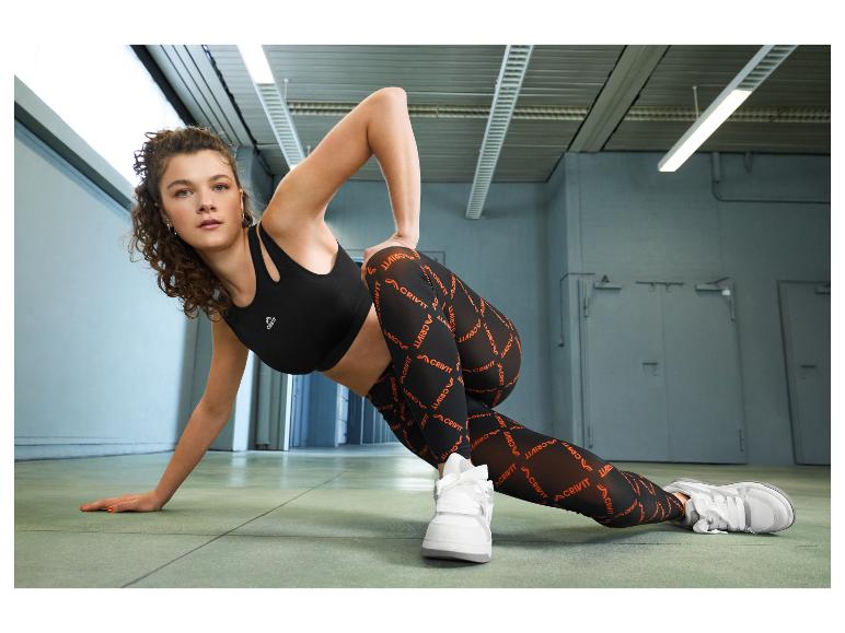 Frau in schwarzem Sport-BH und bedruckten Leggings, beim Sport.