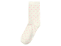 Ein weißer Socken mit kleinen rosa Herzen.