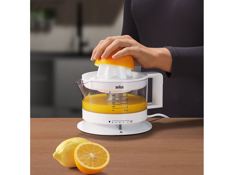 Eine weiße Braun-Zitronenpresse mit Orangensaft, die zum Auspressen von Orangen verwendet wird.