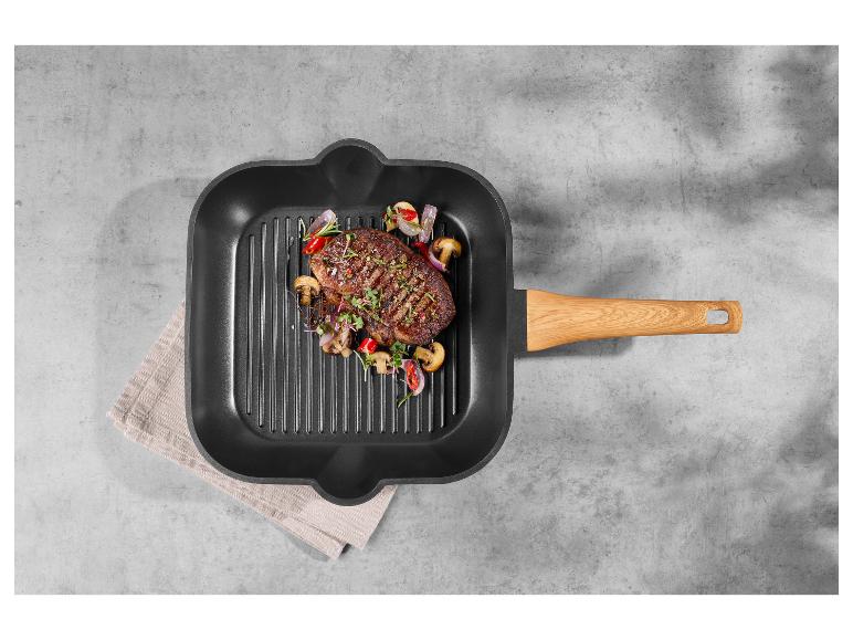 Steak mit Gemüse in einer Grillpfanne mit Holzgriff.