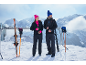 Mann und Frau in Winterkleidung und Skiausrüstung in den Bergen.