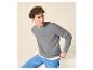 Junger Mann mit lockigem Haar trägt einen gerippten grauen Pullover und blaue Jeans.