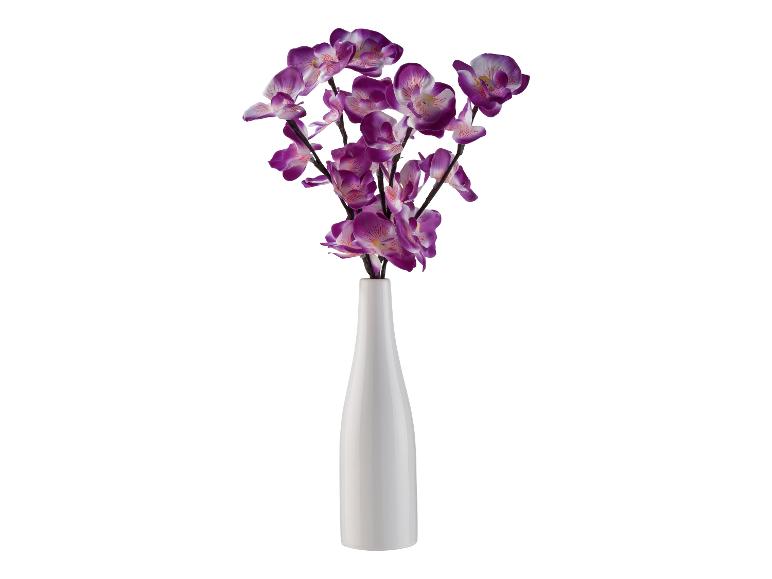Künstliche lila Orchideen in einer weißen Vase