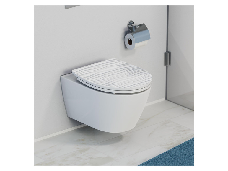 Ein weißes Wand-WC mit einer gewellten Toilettensitz in einem modernen Badezimmer.