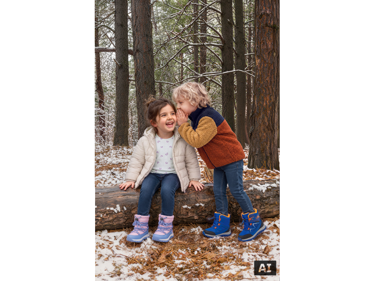 Kinder in Winterkleidung und Stiefeln spielen im verschneiten Wald.