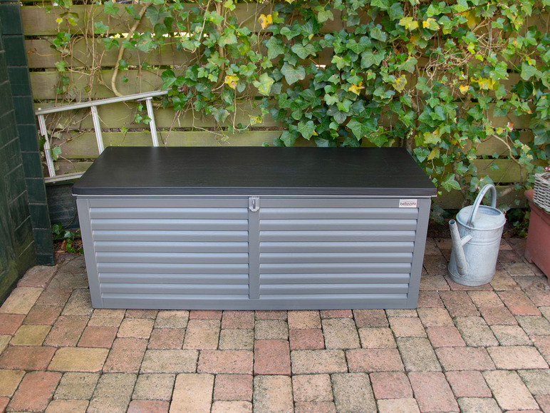 Ein grauer Aufbewahrungskasten mit einem bellavista-Logo in einem Garten.