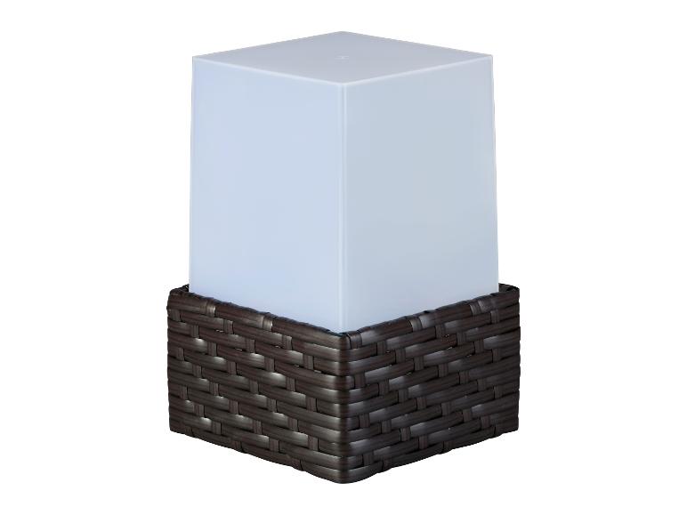 Eine weiße Lampe in einem dunkelbraunen Rattan-Korb