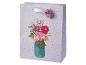 Lila Geschenktüte mit Punkten und einem Blumenstrauß in einem Glas, mit Blumenanhänger.