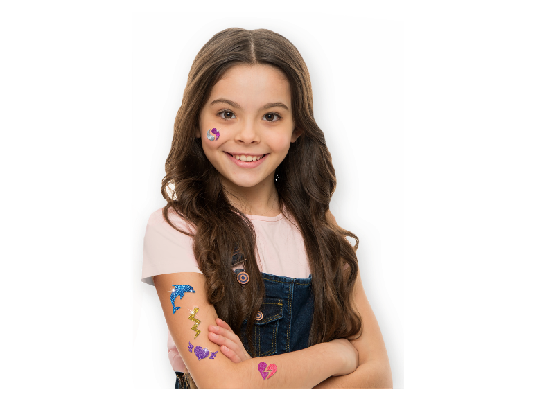 Lächelndes Mädchen mit Glitzer-Tattoos von Delfinen, Blitzen und gebrochenen Herzen.