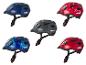 Vier verschiedene Kinderfahrradhelme mit verschiedenen Designs.