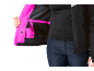 Frau in schwarzer Jacke mit pinkem Futter und dunkelblauer Hose.