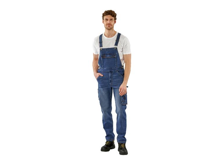 Mann in blauer Jeans-Latzhose und weißem T-Shirt, Hand in der Tasche.