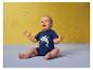 Baby in blauem Haifisch-T-Shirt spielt mit Seifenblasen.