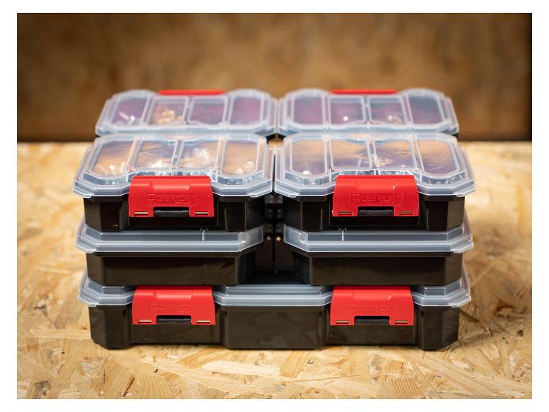 Vier gestapelte Aufbewahrungsboxen mit transparenten Deckeln und roten Verschlüssen auf Holzoberfläche.