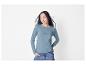 Frau in hellblauem Pullover und Jeans.