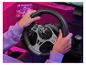 Hände halten ein Gaming-Lenkrad mit Schalthebel auf einem pink beleuchteten Schreibtisch.