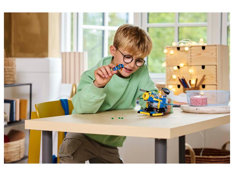 Ein Junge baut ein Lego Sonic the Hedgehog Fahrzeug auf einem Holztisch.