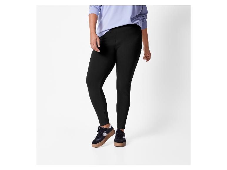 Eine Frau in schwarzen Leggings und einem lila Langarmshirt.