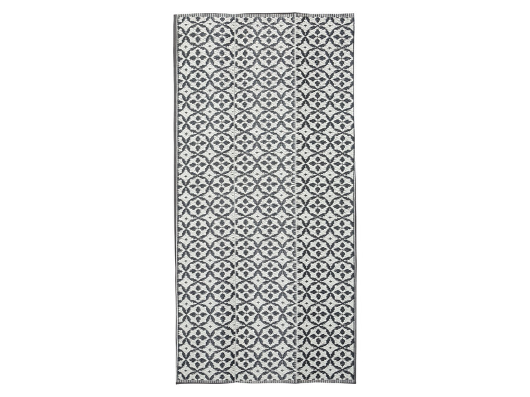 Ein langer, weißer und grauer Teppich mit geometrischem Muster.