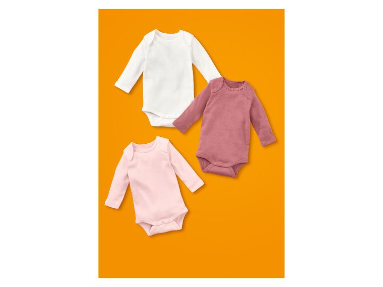 Drei langärmelige Babybodys in Weiß, Hellrosa und Dunkelrosa.