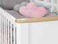 Weißes Babybett mit Holzrand und rosa Kissen