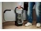 Ein Mann hält ein klappbares Fitnessgerät mit Digitalanzeige.