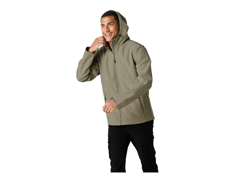 Mann in hellgrüner Kapuzenjacke und schwarzer Cargohose, lächelnd.