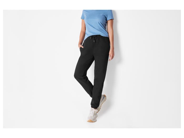 Schwarze Jogginghose mit weißen Sneakers.