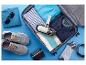Offener Koffer mit Kleidung, Schuhen, Sonnenbrille und Handstaubsauger, bereit für die Reise.