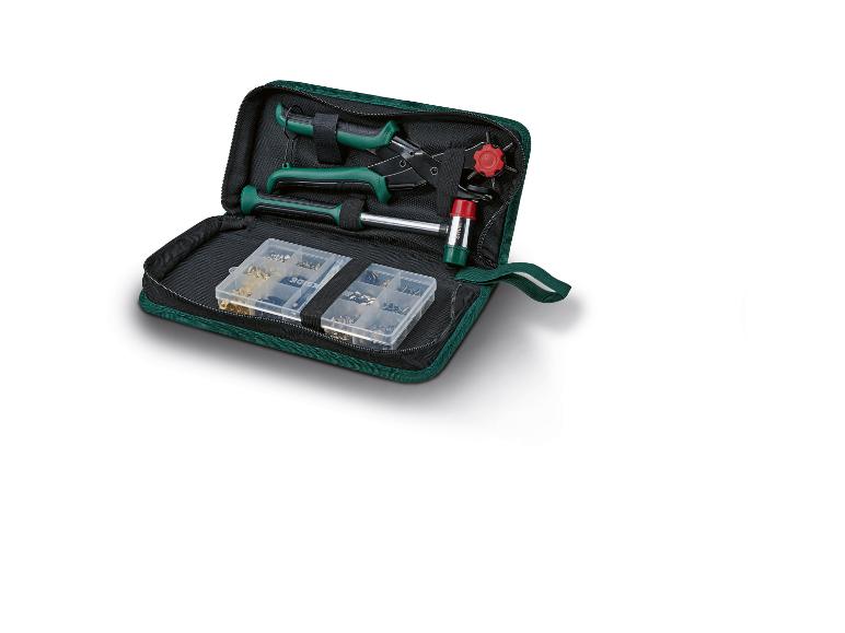 Grünes Werkzeugset mit Zange, Hammer und Kleinteilen in einer Tasche.