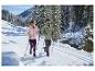 CRIVIT Damen Thermo-Softshelljacke, Mann und Frau wandern in verschneiter Landschaft.