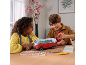 Kinder setzen am Tisch ein 3D-Puzzle eines rot-weißen Campingbusses zusammen.