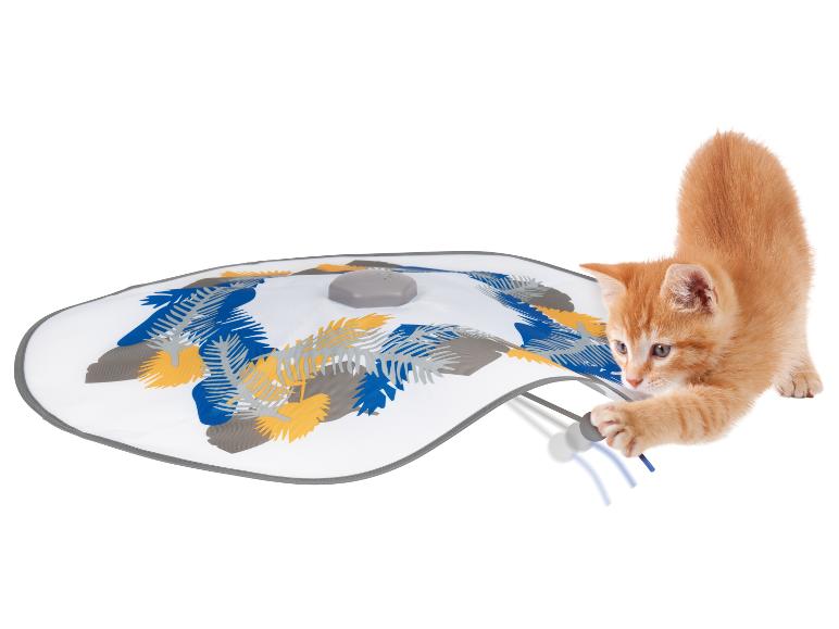 Eine Katze spielt mit einem interaktiven Kratzbaum mit Blättermotiv.