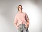 Frau trägt den ESMARA® Premium Mohair-Mix-Pullover in Rosa und eine graue Hose.