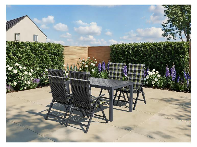 Terrassen-Essgruppe mit grauem Tisch und vier Stühlen mit karierten Kissen im Garten.