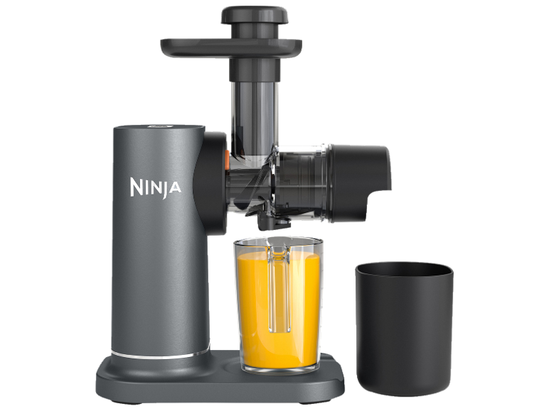 Slow Juicer mit Orangensaft im Glas und Tresterbehälter.