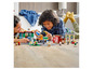 Kinder spielen mit LEGO City Sets, darunter eine Tankstelle und eine Pizzeria.