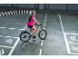 Frau auf E-Bike auf einem Trainingsparcours mit weißen Kegeln.