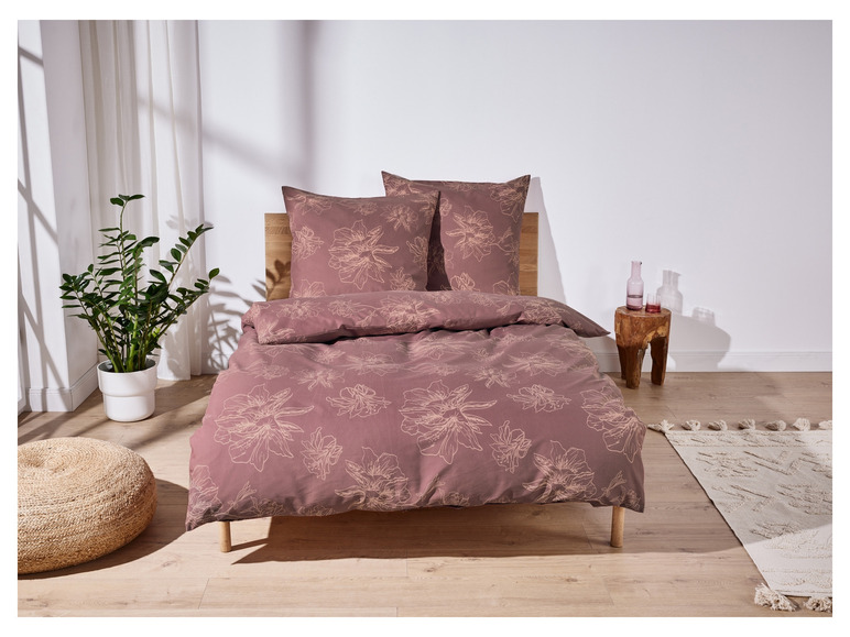 Ein rosafarbenes Bettbezug-Set mit Blumenmuster, einschließlich Kissenbezügen.